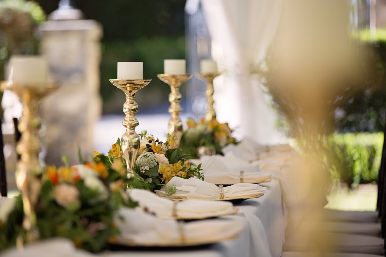 Home Luxurious outdoor wedding table setting with flowers and candlesticks.